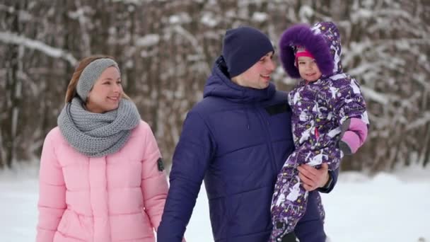 Счастливая семья на закате. Отец, мать и двое дочерей веселятся и играют на снежной зимней прогулке на природе. Ребенок сидит на плечах своего отца. Зимний сезон заморозков . — стоковое видео