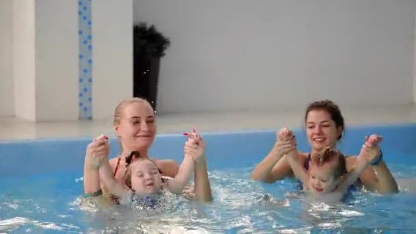 Группа мам со своими маленькими детьми на занятиях по плаванию — стоковое видео