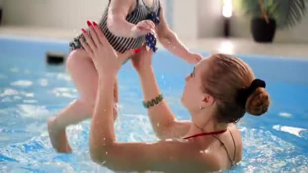 Mosolygó kisgyermek boldog jumping és a búvárkodás a medencében a víz alatt. Egy víz alatti szemcsésedik. Slow Motion — Stock videók