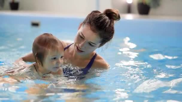 幸せな笑顔の幼児はジャンプ、スイミング プールの水の下でダイビングします。水中のショット。スローモーション — ストック動画