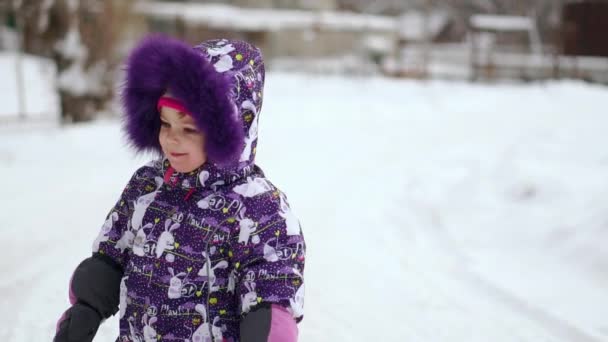 Chica sonriendo mirando a la cámara en el invierno en la calle — Vídeo de stock