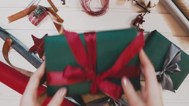 Vista dall'alto. Tavolo marrone in legno decorato con roba natalizia e ghirlande. Luci rosse di Natale. Da vicino. . — Video Stock
