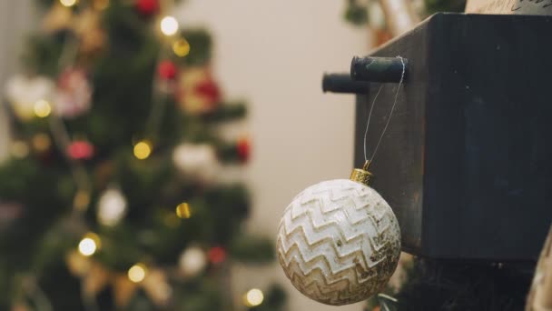 Weihnachtsschmuck am Baum mit Weihnachtsbeleuchtung aufhängen. Weihnachtsbaum mit Kugel schmücken. — Stockvideo