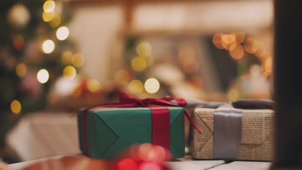 Θέμα Χριστουγέννων. Νεαρή γυναίκα βάζει τα δώρα κάτω από το χριστουγεννιάτικο δέντρο. Για την εξουσιοδοτημένη παρέμβαση ή Μασκάρισμα. — Αρχείο Βίντεο