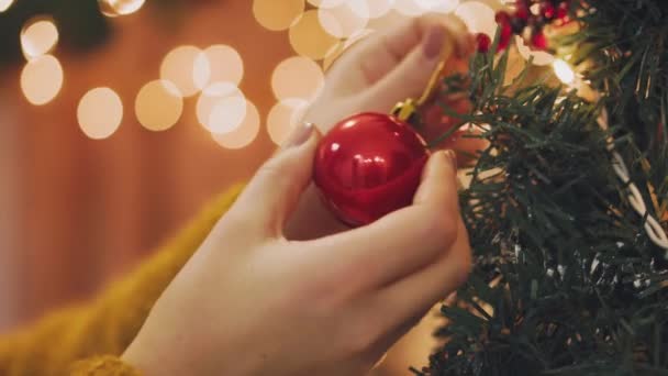 Hand vrouw versieren op kerstboom met Kerstmis glow lights. — Stockvideo