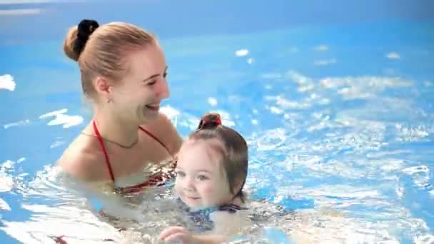 Lindo bebé disfrutando con su madre en la piscina . — Vídeos de Stock