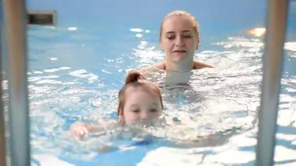 Die Babys, die oben aus dem Schwimmbad kommen, helfen der Mutter in Zeitlupe — Stockvideo