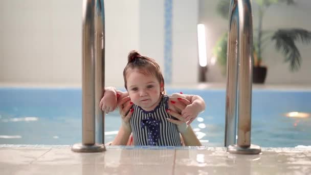 The cute baby getting out from the swimming pool — Stock Video