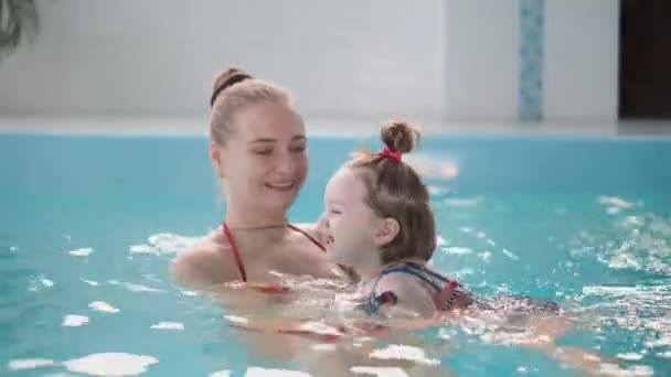 Lindo bebé disfrutando con su madre en la piscina . — Vídeo de stock