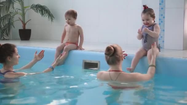 Úszás a medencében ravasz imádnivaló baba boldog középkorú anya. Mosolyog, anya és kis gyermek, újszülött lány együtt szórakoztunk. Aktív családi eltöltött szabadidő- és wellness hotel. — Stock videók