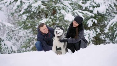 Kadın ve erkek köpek karda oynamak.