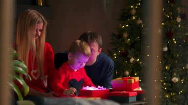 Bir Noel hediyesi hediye açılış mutlu bir aile portresi akşamları kutu. Tatil, e-ticaret online alışveriş, sürpriz, mutlu bir aile kavramı.