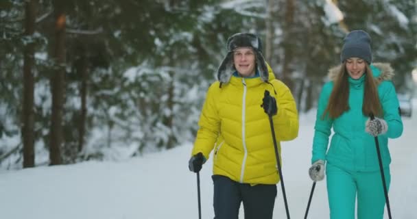 Loving man and woman in slow motion winter skiing in the woods looking at each other smiling. Valentine day — Stock Video