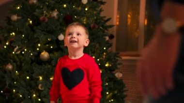 Mutlu anne ve bebek portre Noel kutlaması. Yeni yıl tatilleri. Toddler anne Noel ağacı ve süslemeleri ile festively bir şekilde dekore edilmiş oda ile. Bebek Çocuk ile anne