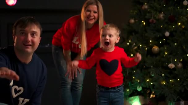 Schattig baby jongetje plezier op een kerstavond thuis, lachen en rondrennen met een kerstcadeau. — Stockvideo