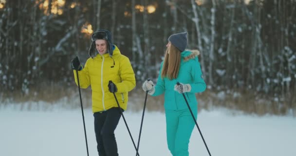 Man och kvinna i kärlek med skidutrustning kommer att ski terräng — Stockvideo