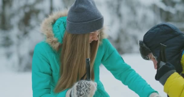 Un uomo e una donna che sciano nella foresta invernale — Video Stock