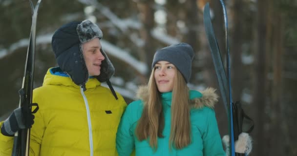 Pareja mayor activa en esquís que baja por la nieve en nevadas durante el entrenamiento en el bosque de invierno — Vídeos de Stock