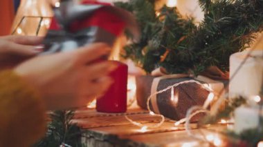Yaratıcı hobi. Hediye. Saten kurdele ile şık gri kağıt modern Noel hediyesi ambalaj kutuları. Eller üstten görünüm köknar ağacı dalları, dekorasyon Beyaz ahşap tablo