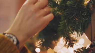Noel ağacı Noel ile dekorasyon el kadın parlayan ışıklar.