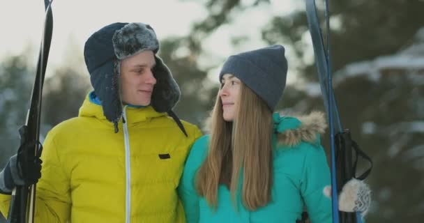 Amoureux gars et fille ski dans la forêt d'hiver au ralenti souriant et se regardant — Video