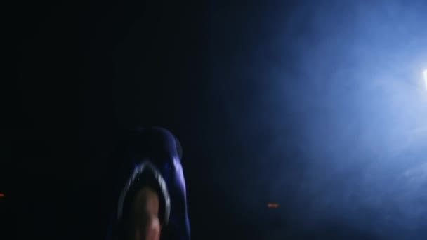 Дівчинка-гімнастка виконує перевертання на гімнастичному килимі при повільному русі на задньому світлі в диму — стокове відео