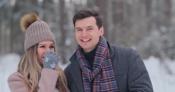 Mladý manželský pár v lásce chůze v zimním lese. Muž a žena se na sebe a smíchu v pomalém pohybu. Valentýna milostný příběh. — Stock video