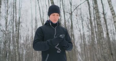 Kış siyah bir çekiç bir genç adam olarak dürtmek hazırlanıyor parkta bir uygulama çalıştırmak için içerir ve orman iş yapmak ve sağlıklı bir önde gelen bir ses asistanı ile çalışır