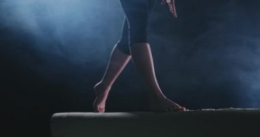 Spor salonunda bir denge aleti üzerinde pratik kız jimnastikçi.