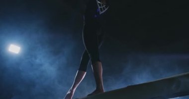 Bayan Artistik Jimnastik. Duman ağır çekimde kızı Olimpiyat programının karmaþýk öðeler bir denge aleti üzerinde gerçekleştirir.