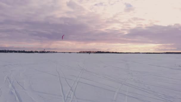 Un atleta masculino en traje deportivo está haciendo kite de nieve en el hermoso paisaje de invierno — Vídeos de Stock