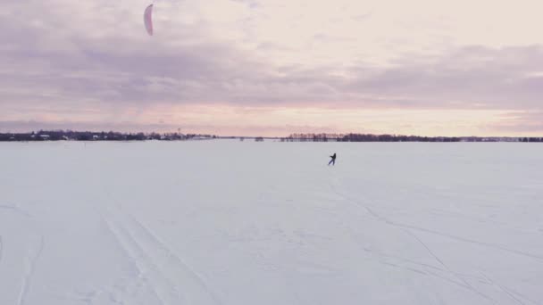 冬天在滑雪板或滑雪上冲浪。在风中的冰上溜冰。美丽的彩色帆. — 图库视频影像