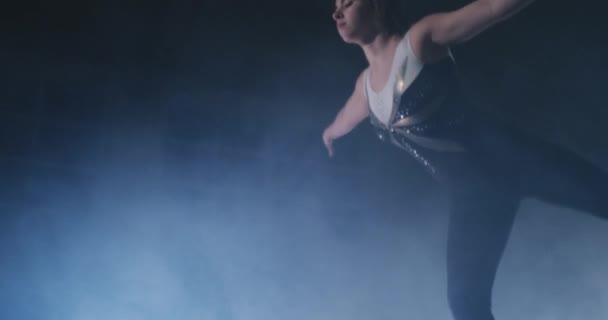 У повільному русі в диму, дівчина-спортсмен стоїть з піднятими руками після виконання вправ. Ласкаво просимо жест руками . — стокове відео
