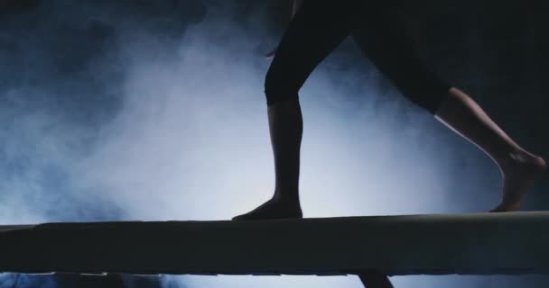 Jambes Les gymnastes professionnelles sautent au ralenti dans la fumée sur le faisceau d'équilibre. Femmes Gymnastique artistique — Video