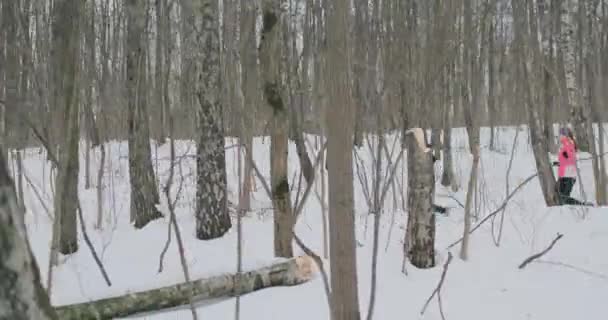 Un homme et une femme courent dans le parc en hiver, pratiquent un mode de vie sain et socialisent avec leur santé dans le parc . — Video