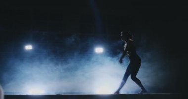 Bayan Artistik Jimnastik. Duman ağır çekimde kızı Olimpiyat programının karmaþýk öðeler bir denge aleti üzerinde gerçekleştirir.