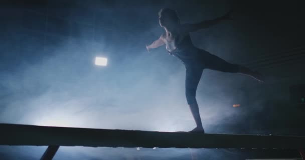 У повільному русі в диму, дівчина-спортсмен стоїть з піднятими руками після виконання вправ. Ласкаво просимо жест руками . — стокове відео