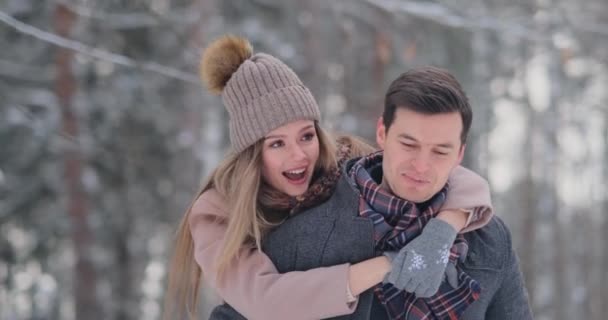 Jeune beau couple prenant plaisir et souriant en plein air en hiver enneigé — Video