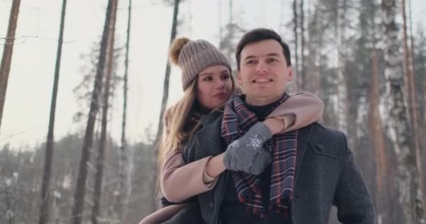 Jeune beau couple prenant plaisir et souriant en plein air en hiver enneigé — Video