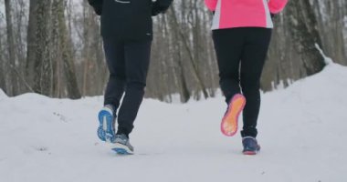 Kışın parkta çalışan spor ayakkabı iki kaçakçıları metrelik close-up. Spor için evli çift giriyor.