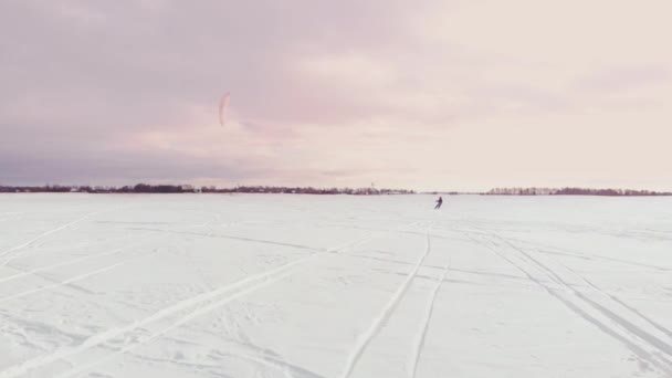 冬天在滑雪板或滑雪上冲浪。在风中的冰上溜冰。美丽的彩色帆. — 图库视频影像