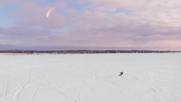 Un atleta masculino en traje deportivo está haciendo kite de nieve en el hermoso paisaje de invierno . — Vídeo de stock