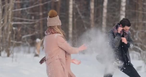 Young couple playing outdoors. Winter season. — Stock Video