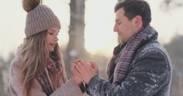 Una coppia innamorata un uomo riscalda le mani con il suo respiro una donna. Elegante coppia nel Parco in inverno per una passeggiata . — Video Stock