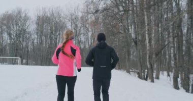 Pozitif güzel genç sağlıklı çift ile orman yoluyla spor giyim kış sabahları çalıştıran