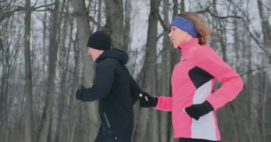 Pozitif güzel genç sağlıklı çift ile orman yoluyla spor giyim kış sabahları çalıştıran