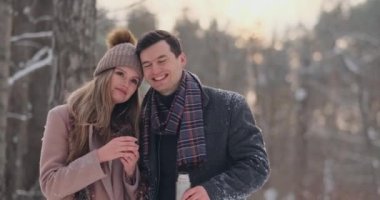 Güzel ve şık bir çift erkek ve kadın hipsters Paltonu ve kaşkolünü içinde bir yürüyüşten sonra bir termos kış orman içinde gelen çay iç. Aşk hikayesi