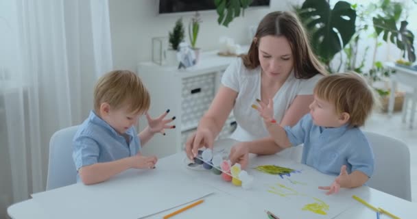 Två barn till pojkar och mor är engagerade i kreativ utveckling gör läxor av fingersättning på papper. Utvecklingen av taktila förnimmelser och små matematik. — Stockvideo