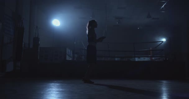 Hermosa mujer boxeadora saltando en el gimnasio de boxeo cerca del ring en los jerséis — Vídeo de stock