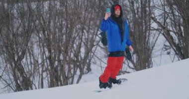 Erkek snowboard kar yamaç ve Smartphone-e doğru senin sokulgan için yazmak için yönetim kurulu Kayak rides